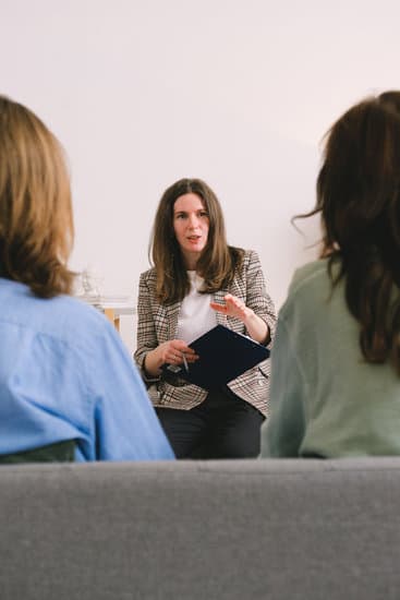 Woman psychologist consulting clients in light room